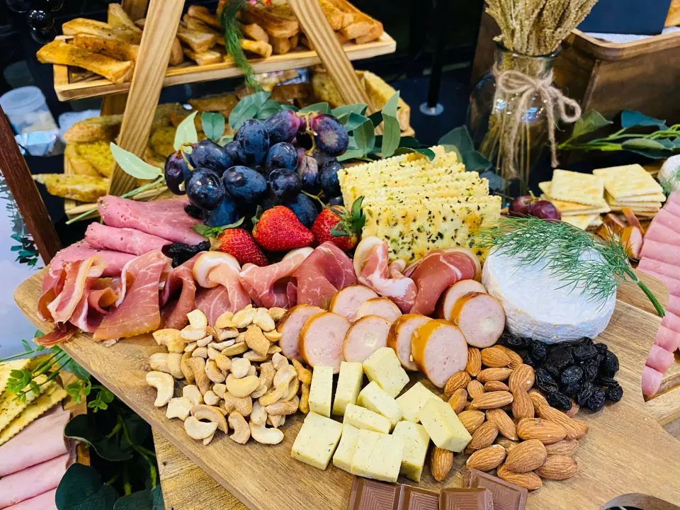 Charcuterie board prepared with cheese, nuts, fruit, and crackers