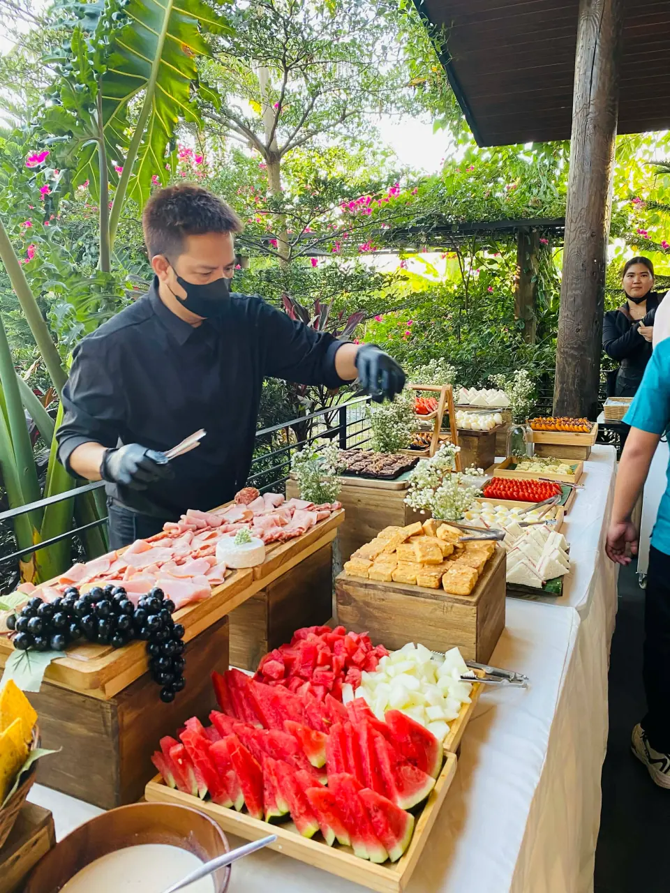 Grazing table arranged with cold cuts, cheese, fruit, and crackers