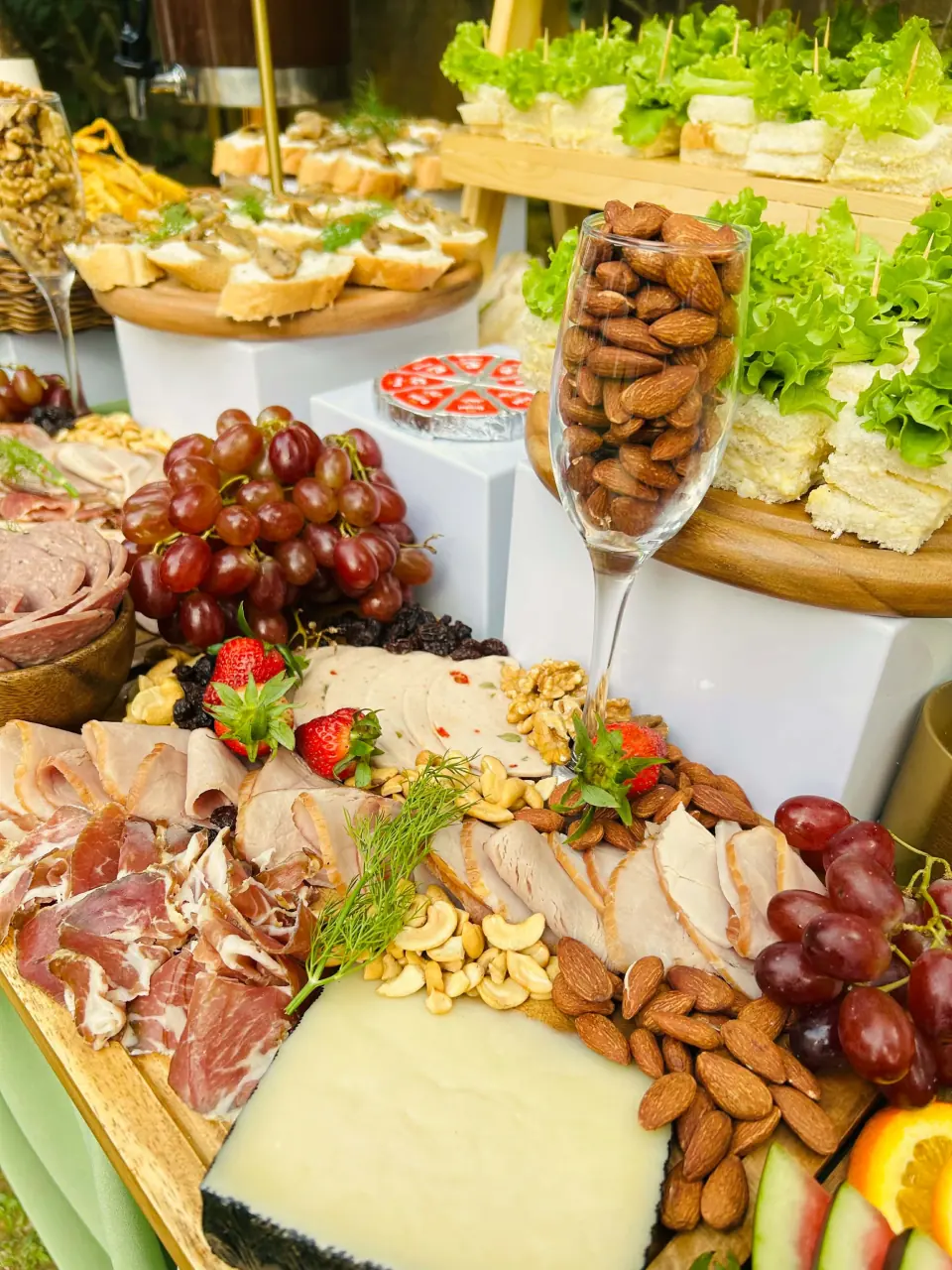 Grazing table featuring sandwiches, almonds, and savory bites